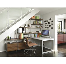 Büroeinrichtung unter einer Treppe mit Regalen, Schreibtisch und Bürostuhl in einem hellen Raum