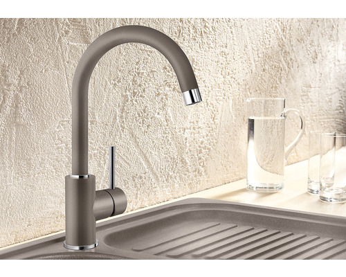 Küchenarmatur neben Spülbecken mit Wasserkanne und Gläsern