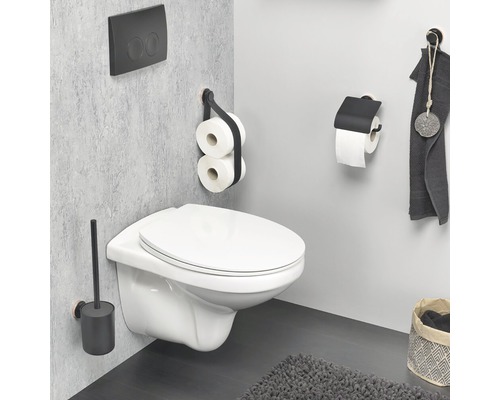 Badezimmer mit wandhängendem WC, Toilettenbürste, Toilettenpapierhalter und Betätigungsplatte