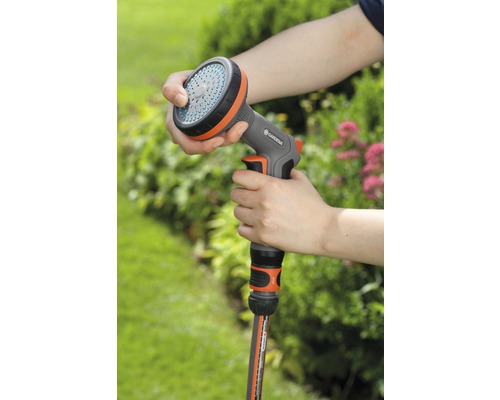 Person hält eine Gardena Brause in der Hand, verbunden mit einem Gartenschlauch.