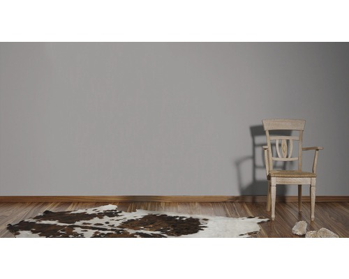 Zimmer mit Holzfußboden, Kuhfellteppich und Holzstuhl