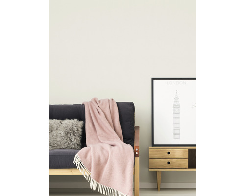 Wohnzimmer mit Sofa, Kissen, Decke und Beistelltisch mit Bilderrahmen