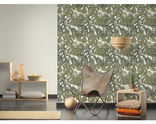 Wohnzimmer mit Monstera-Tapete, Sessel und Holzelementen für eine natürliche Atmosphäre