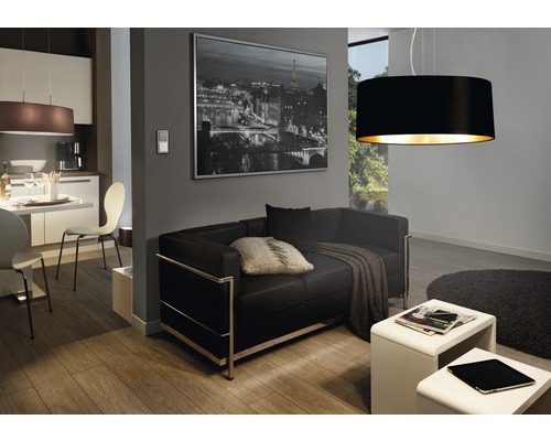 Wohnzimmer mit schwarzem Ledersofa, Couchtischen, Esstisch und Hängelampen