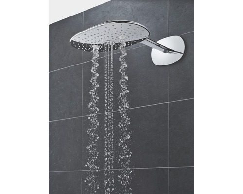 Kopfbrause mit Wasserstrahl vor gefliester Wand