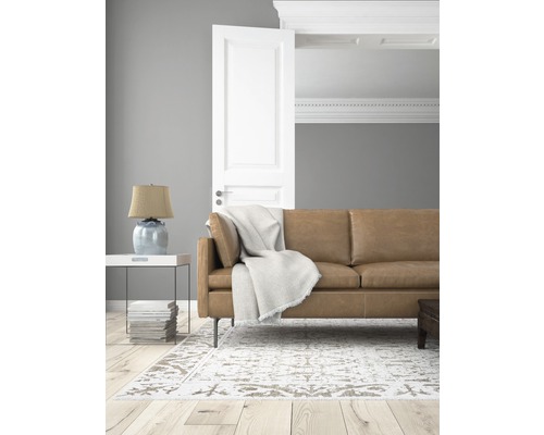 Wohnzimmer mit Ledersofa, Teppich und offener Tür