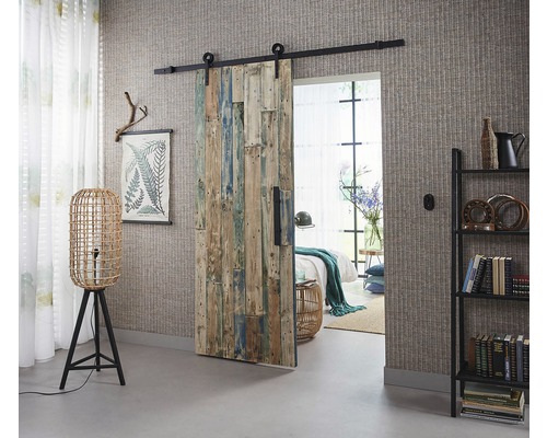 Zimmer mit Schiebetür aus Holz, Stehlampe und Bücherregal