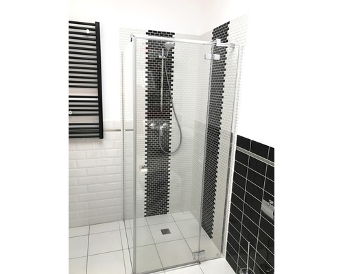 Begehbare Dusche mit Glasabtrennung und schwarzem Heizkörper im Badezimmer.