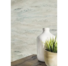 Detailaufnahme einer Wandtapete mit Wellenmuster neben einer weißen Vase und einer Topfpflanze