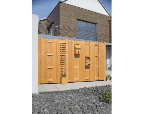 Holzzaun mit Insektenhotel, Vogelhaus, Rankgitter und Blumenkasten im Garten