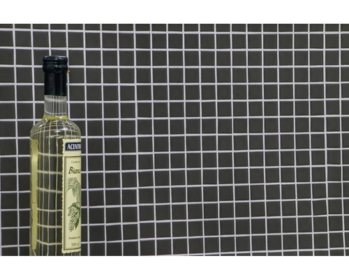 Essigessenz in Glasflasche vor dunklem Mosaikhintergrund