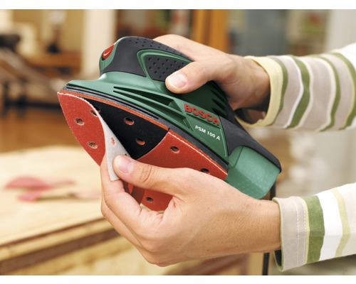 Eine Person wechselt Schleifpapier an einem Bosch PSM 100 A Multischleifer.