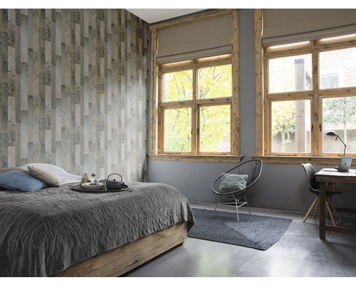 Schlafzimmer mit Bett, Schreibtisch und Holzvertäfelung an der Wand
