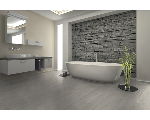 Badezimmer mit Badewanne, Waschtisch und Steinwand