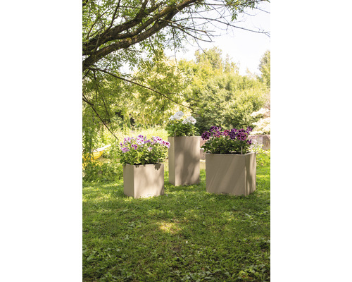 Drei Pflanzgefäße mit Blumen im Garten