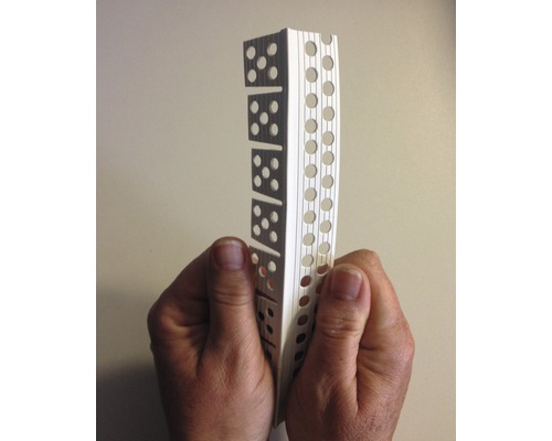 Eine Person hält ein Putzprofil mit Löchern und Aussparungen.