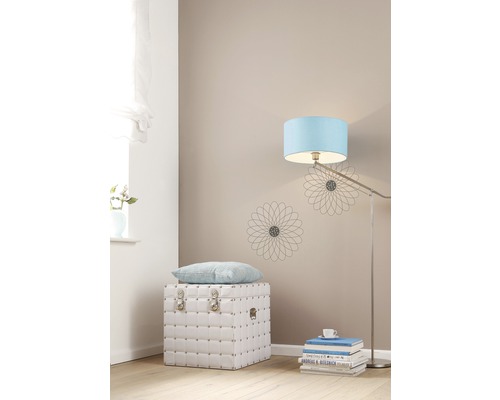 Heller Raum mit weißer Truhe, Kissen, Stehlampe und Dekoration