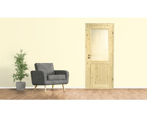 Holztür mit Glaseinsatz neben einem Sessel und einer Zimmerpflanze