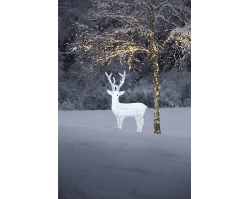 Beleuchtete Dekoration mit Rentierfigur und Baum im verschneiten Außenbereich
