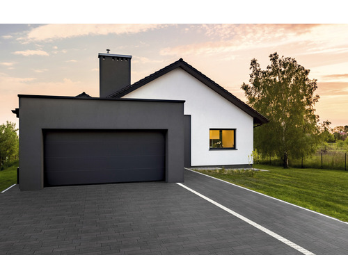 Modernes Einfamilienhaus mit Garage und gepflasterter Auffahrt.