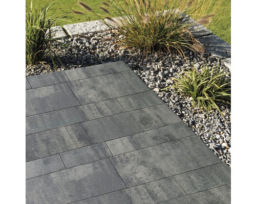 Gartenweg aus grauen Betonpflastersteinen mit Kiesbeet