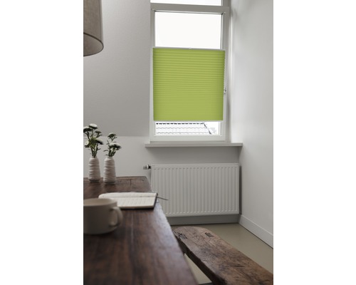 Helles Zimmer mit Faltschiebevorhang am Fenster, Tisch, Bank und Heizkörper.