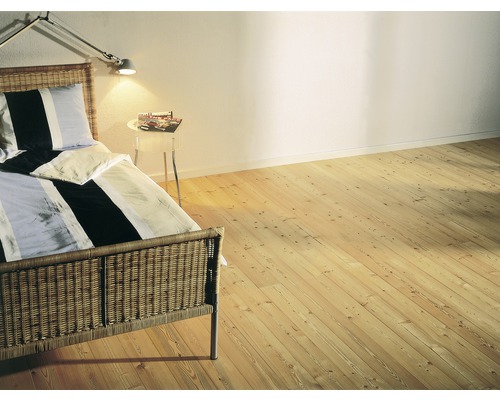 Schlafzimmer mit Holzboden, Bett und Nachttisch.