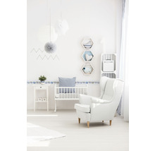 Helles Kinderzimmer mit Kinderbett, Sessel, Beistelltisch und Wanddekoration