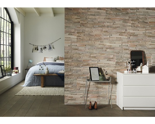 Dekorative Steinwand im Schlafzimmer mit Bett und Kommode