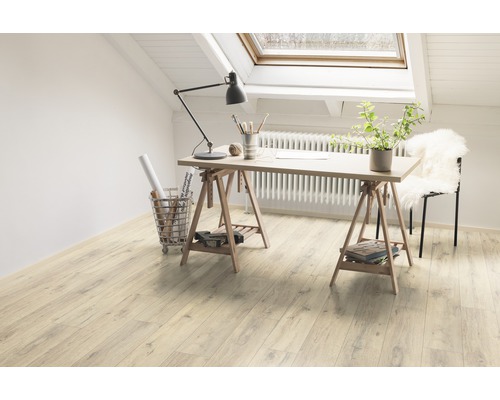 Heller Raum mit Schreibtisch auf Holzböden unter einem Dachfenster.