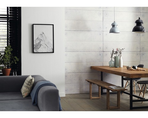 Wohnzimmer mit Sofa, Esstisch, Bank und Wandpaneelen in Betonoptik.