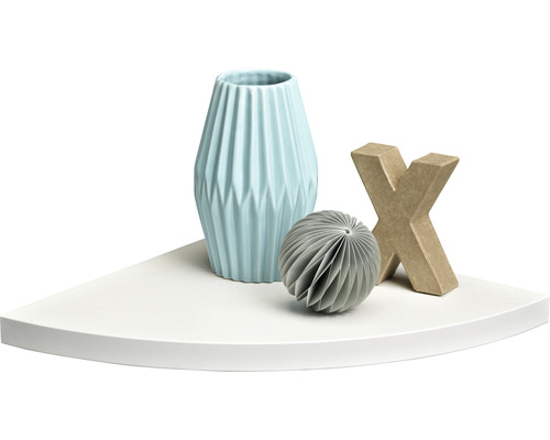 Dekorative Elemente auf einem weißen Eckregal: eine Vase, ein Papierball und ein Buchstabe.