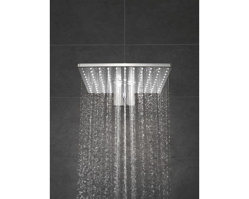 Quadratische Regendusche mit fließendem Wasser vor dunklem Hintergrund