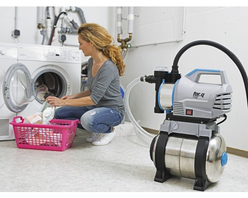 Hauswasserwerk im Einsatz im Waschkeller neben einer Waschmaschine mit Wäschekorb