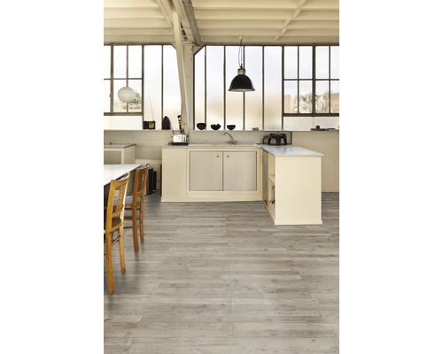 Heller Raum mit Küchenzeile und Holzboden.