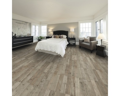 Schlafzimmer mit Bett, Kommode, Sessel und Holzboden