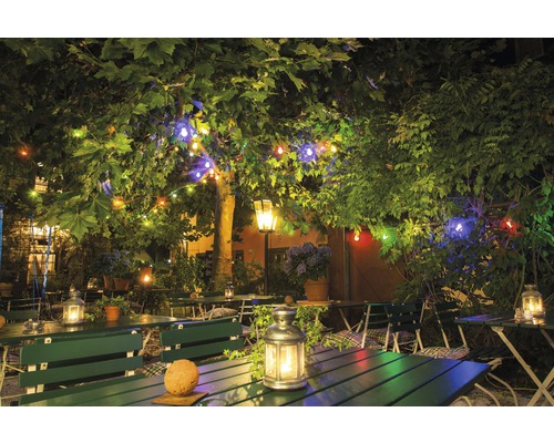 Restaurantgarten mit Tischen, Bänken und Lichterketten