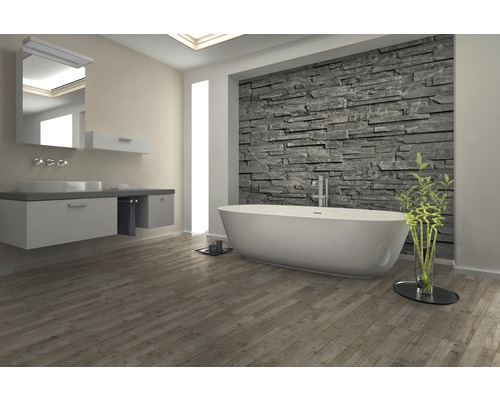 Helles Badezimmer mit Badewanne, Waschbecken und Steinwand