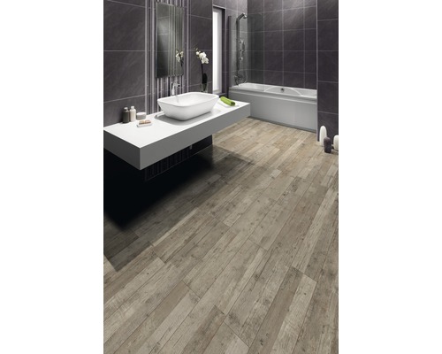 Badezimmer mit Badewanne, Waschbecken und Bodenfliesen in Holzoptik