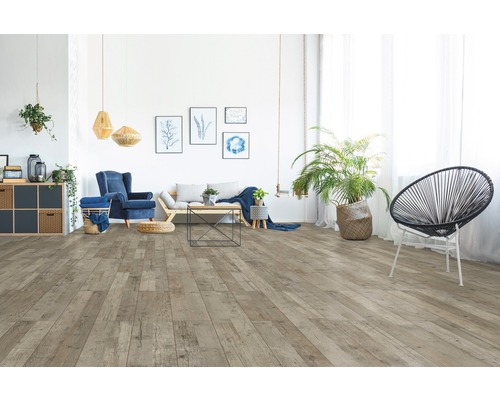 Wohnzimmer mit hellbraunem Holzboden, Sofa, Sessel und Dekorationen für ein gemütliches Ambiente.