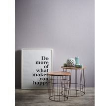 Dekorative Szene mit zwei Beistelltischen, einem gerahmten Motivationsposter und dekorativen Vasen.