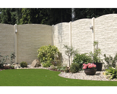 Szene eines Gartens mit einem Zaun in Steinoptik, Pflanzen und Rasen