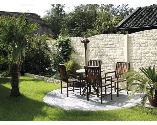 Garten mit Steinmauer, Rasenfläche, Palmen, Tisch und Stühlen