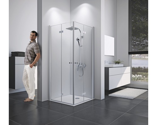 Helles Badezimmer mit Eckdusche, Waschbeckenunterschrank und stehender Person