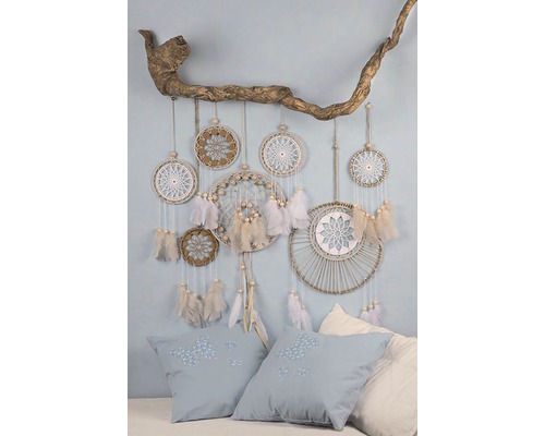 Dekorative Szene mit Traumfängern an einem Ast und Kissen mit Stickerei.