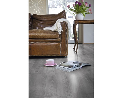 Wohnzimmer mit Ledersofa, Tisch, Tulpen und Laminatboden.