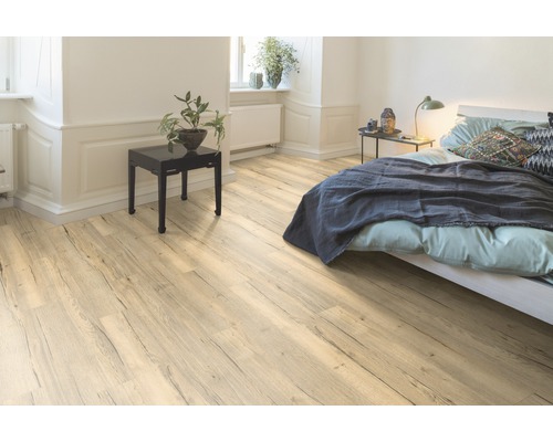 Heller Raum mit Laminatboden in Holzoptik, Bett und Beistelltisch