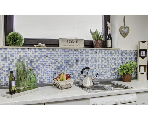 Küchenszene mit Mosaikfliesen, Dekoration und Kochutensilien auf einer Arbeitsplatte.