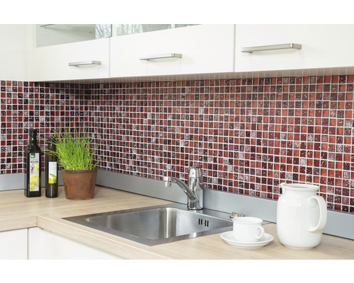 Küchenszene mit Mosaikfliesen, Spüle und Küchenutensilien auf der Arbeitsfläche.