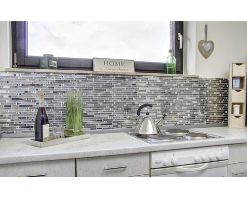 Küchenszene mit Mosaikfliesen, Kochfeld, Teekessel und Dekorationen